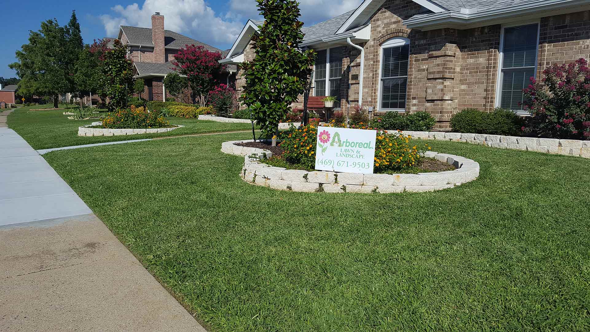 Arboreal signage placed in a maintained lawn bed in Rockwall, TX.