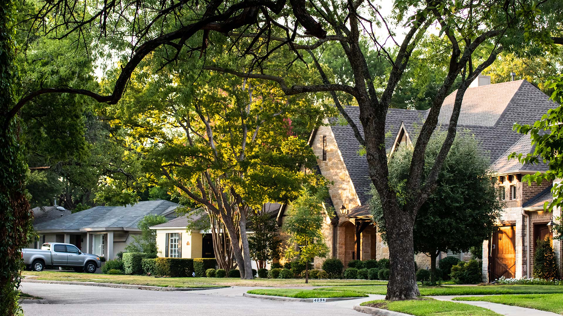 A neighborhood in St. Paul, TX with thick green trees and healthy grass.